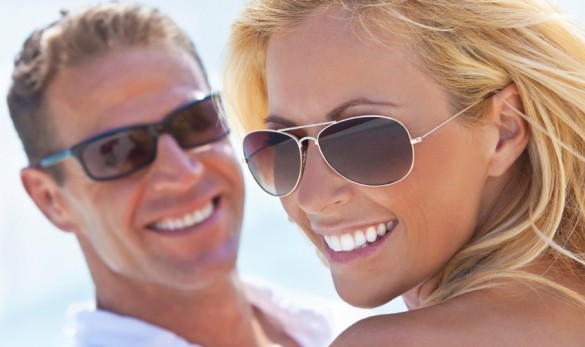 Happy Attractive Woman and Man Couple In Sunglasses At Beach